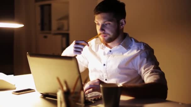 Hombre con laptop y papeles trabajando en la oficina nocturna — Vídeo de stock
