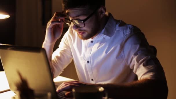 Hombre con portátil y café trabajando en la oficina de noche — Vídeos de Stock