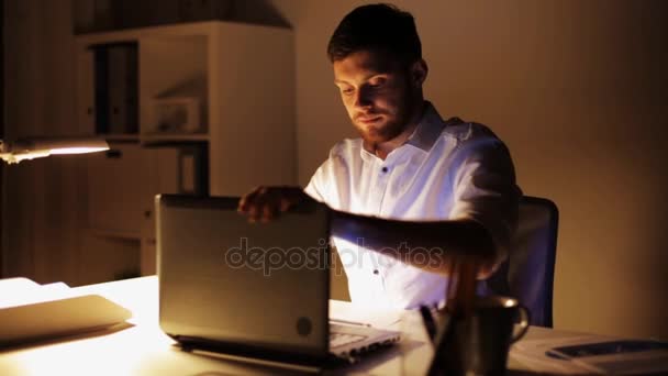 Man with laptop finishing work at night office — Stock Video