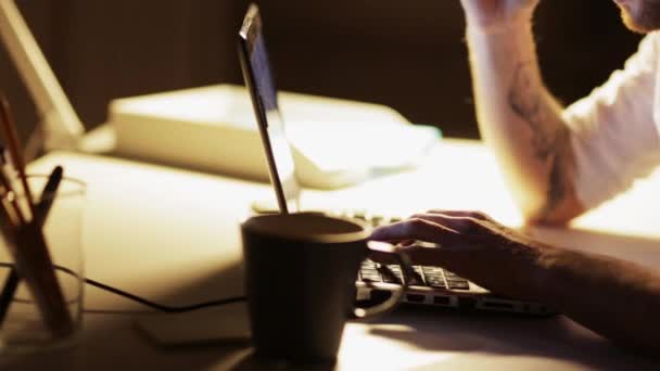 Man with laptop and coffee working at night office — Stock Video