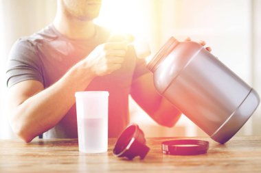close up of man with protein shake bottle and jar clipart