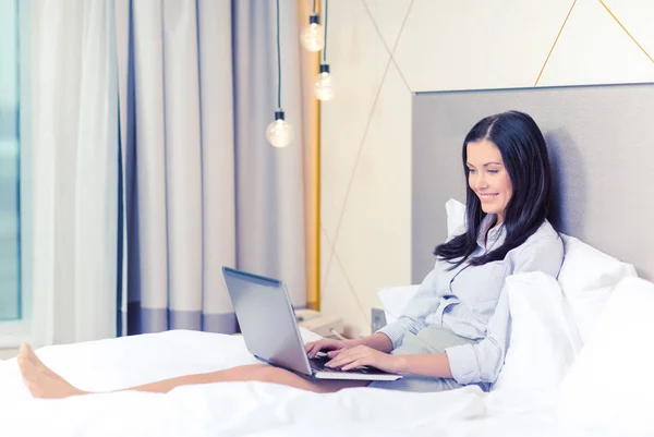 Empresária feliz com laptop no quarto de hotel — Fotografia de Stock