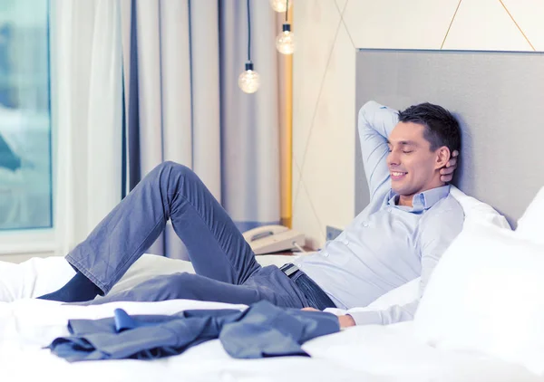 Happy businesswoman lying in bed in hotel room — Stock Photo, Image