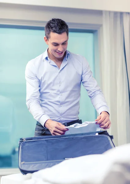 Geschäftsmann packt Sachen in Koffer — Stockfoto