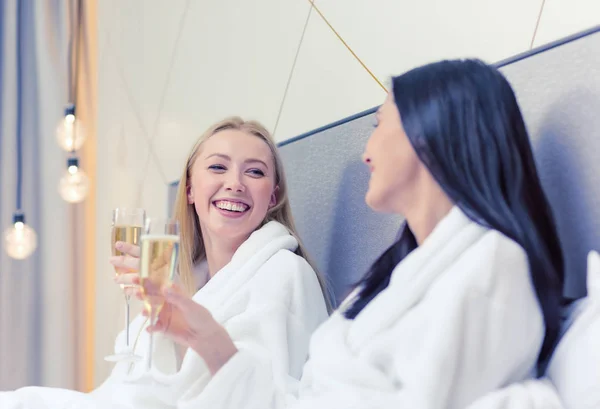 Fidanzate sorridenti con bicchieri di champagne a letto — Foto Stock