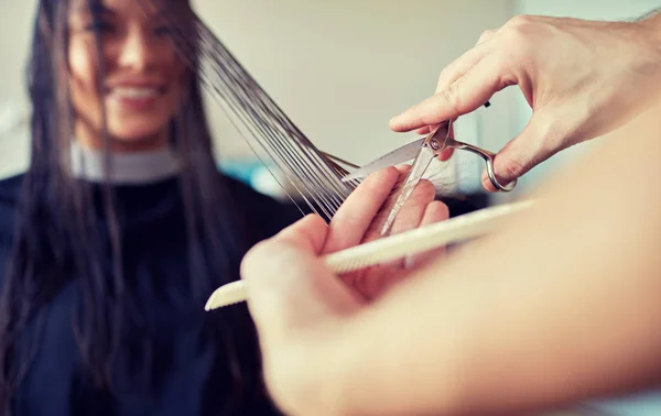 Gelukkige vrouw met stylist snijden haar op salon — Stockfoto
