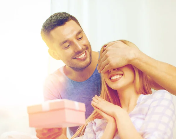Smiling man surprises his girlfriend with present — Stock Photo, Image