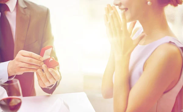 Heyecanlı genç kadın ve erkek arkadaşı ona yüzüğü vermek — Stok fotoğraf