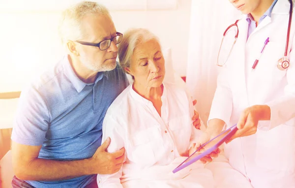 Äldre kvinna och läkare med tablettdator på sjukhus — Stockfoto
