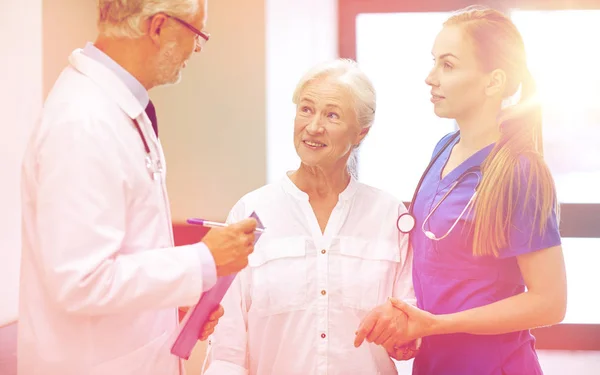 Dokters en senior patiënt vrouw in ziekenhuis — Stockfoto