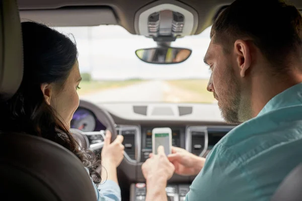 Glücklicher Mann und Frau mit Smartphone im Auto — Stockfoto