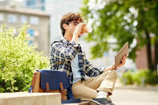 Man with tablet pc and coffee on city street bench — Stock Photo, Image