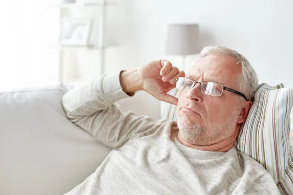 Close up de homem sênior em óculos pensando em casa — Fotografia de Stock