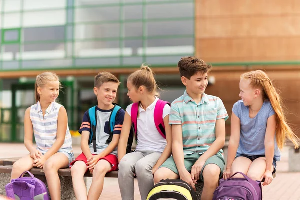 Groupe d'élèves heureux de l'école primaire parler — Photo