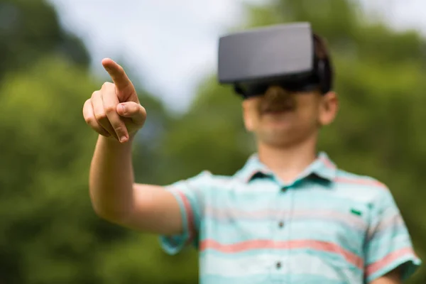 Menino com fone de ouvido realidade virtual ao ar livre — Fotografia de Stock