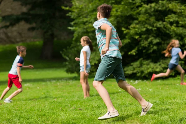 Grupo de niños felices o amigos jugando al aire libre — Foto de Stock