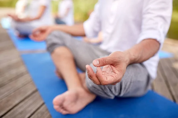 Close up van mensen die yoga-oefeningen buiten — Stockfoto