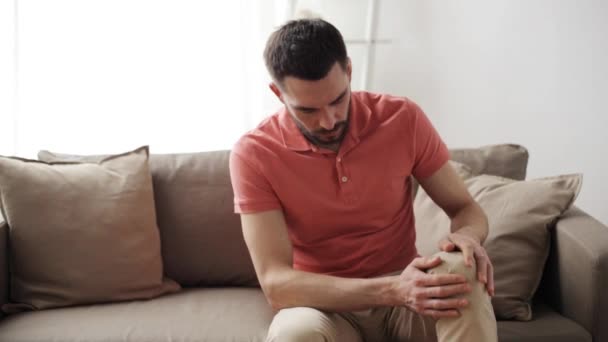 Homem infeliz sofrendo de dor na perna em casa — Vídeo de Stock