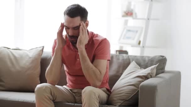 Hombre que sufre de dolor de cabeza en casa — Vídeo de stock