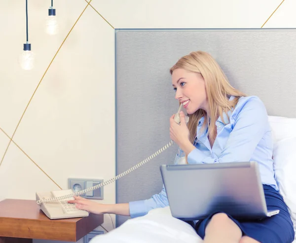 Dizüstü bilgisayar ve telefon otel odasında iş kadını — Stok fotoğraf
