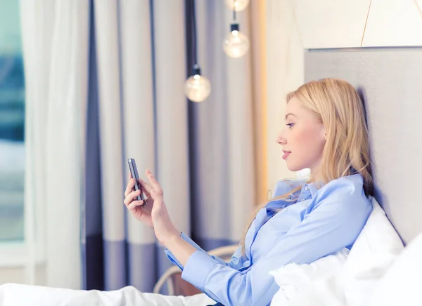 Gelukkig zakenvrouw met smartphone in hotelkamer — Stockfoto