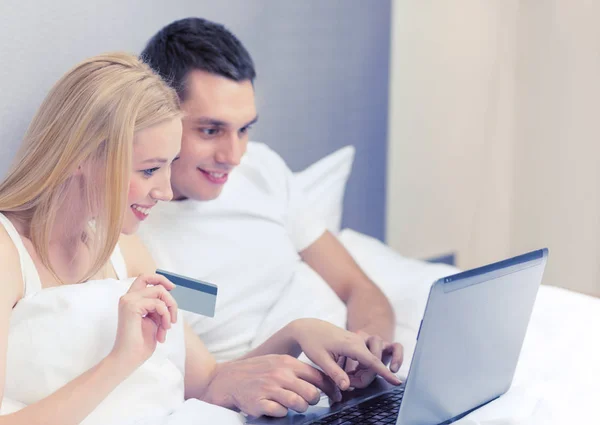 Çift yatakta dizüstü bilgisayar ve kredi kartı ile — Stok fotoğraf