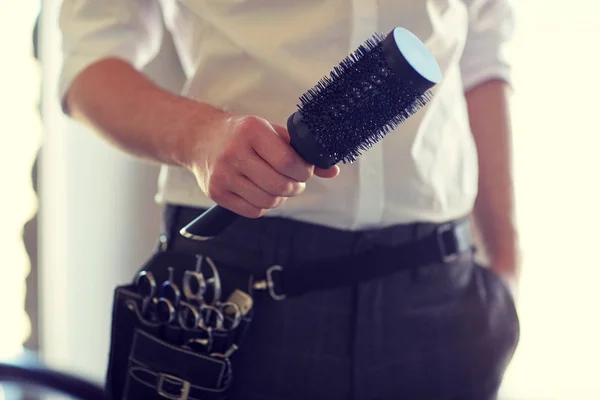 Close up of male stylist with brush at salon — Stock Photo, Image