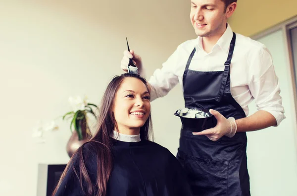 Happy young woman coloring hair at salon — Stock Photo, Image