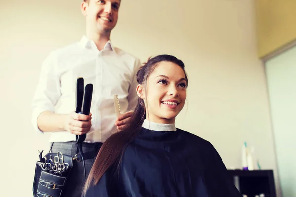 Gelukkig vrouw met stylist maken kapsel in salon — Stockfoto