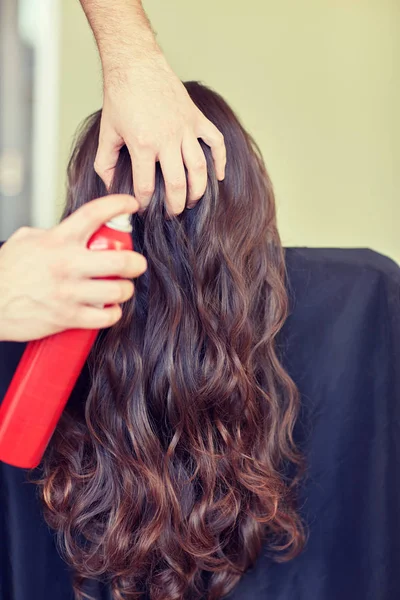 Estilista con spray para el cabello haciendo peinado en el salón —  Fotos de Stock