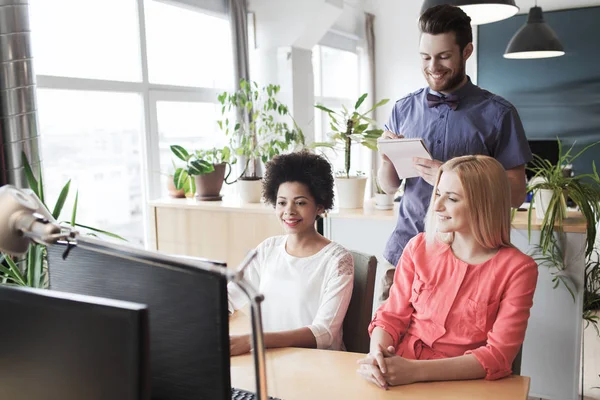 Lykkelig kreativ gruppe med datamaskin i embetet – stockfoto