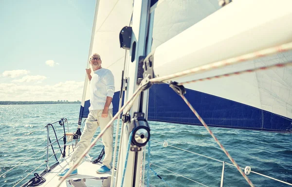 Senior man op zeil boot of jacht zeilen in zee — Stockfoto