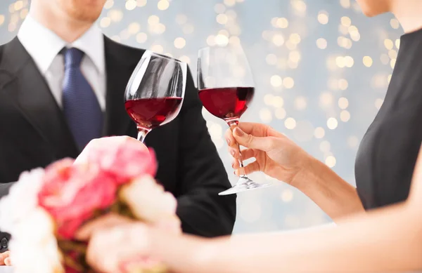 Primer plano de pareja tintineando copas de vino tinto —  Fotos de Stock