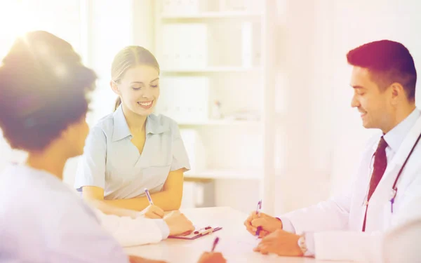 Groep van gelukkig artsen ontmoeting bij ziekenhuis kantoor — Stockfoto