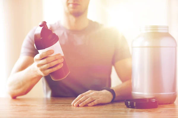 Adamın protein shake şişe ve kavanoz ile yakın çekim — Stok fotoğraf