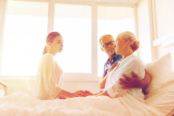 Familia visitando a una anciana enferma en el hospital —  Fotos de Stock