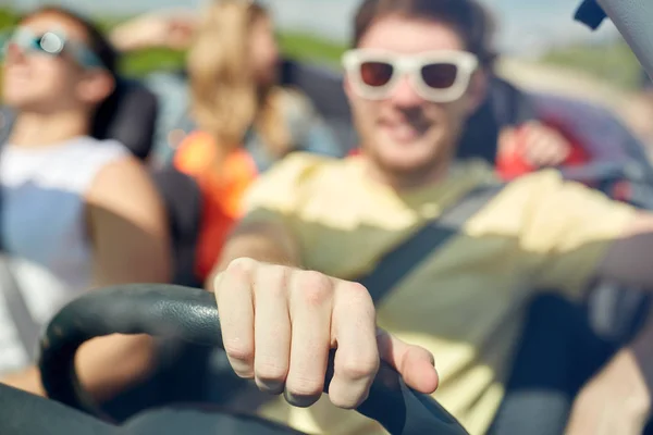 Amigos felizes dirigindo em carro conversível — Fotografia de Stock