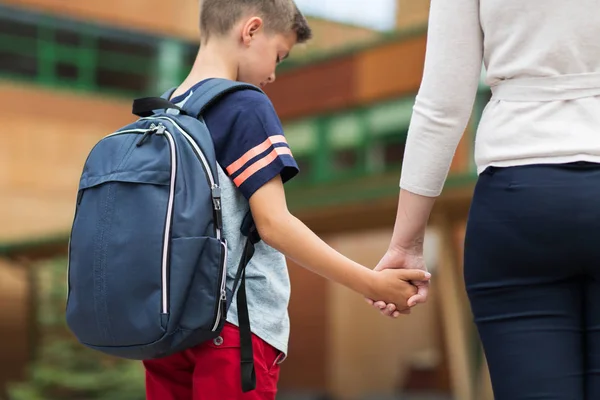 Elementaire student jongen met moeder op schoolplein — Stockfoto