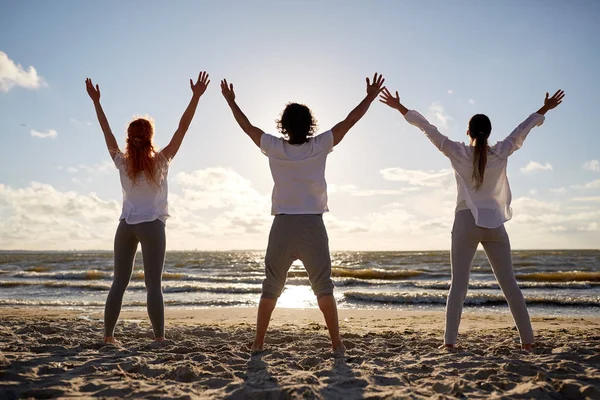 一群人做瑜伽或冥想在海滩上 — 图库照片