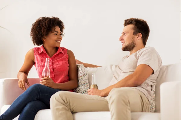 Amigos felizes ou casal com cerveja falando em casa — Fotografia de Stock