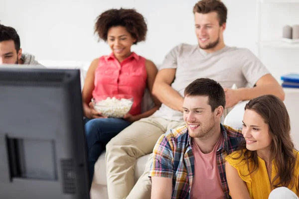 Счастливые друзья смотрят телевизор дома — стоковое фото