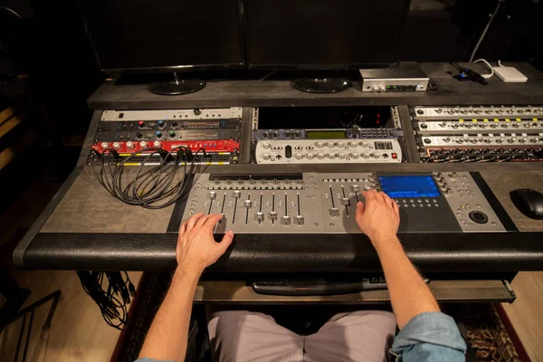 Uomo che utilizza la console di miscelazione in studio di registrazione musicale — Foto Stock