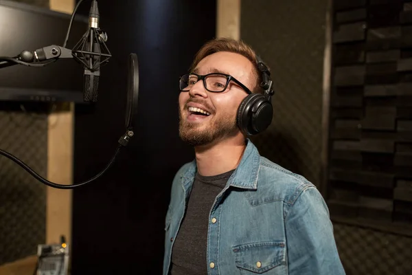 Hombre con auriculares cantando en el estudio de grabación — Foto de Stock