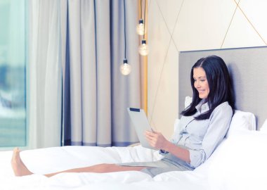 happy businesswoman with tablet pc in hotel room clipart