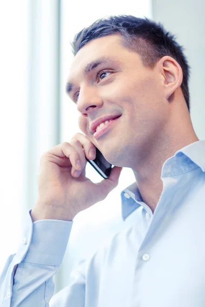 Smiling businessman with smartphone in office — Stock Photo, Image