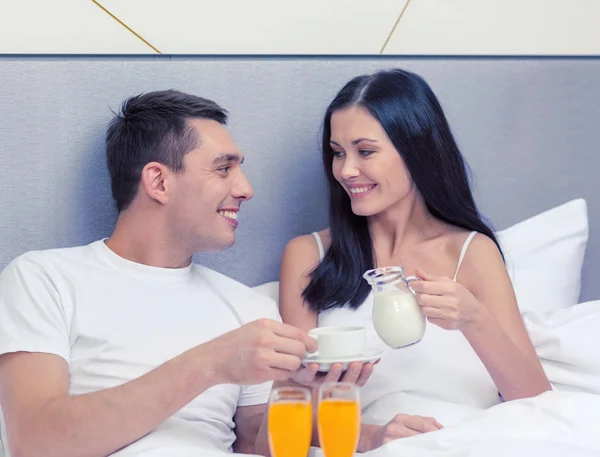 Lachende paar ontbijten in hotel in bed — Stockfoto