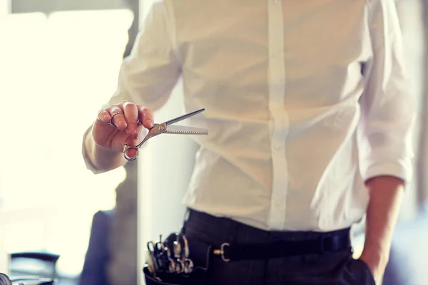 Крупним планом чоловічий стиліст з ножицями в салоні — стокове фото