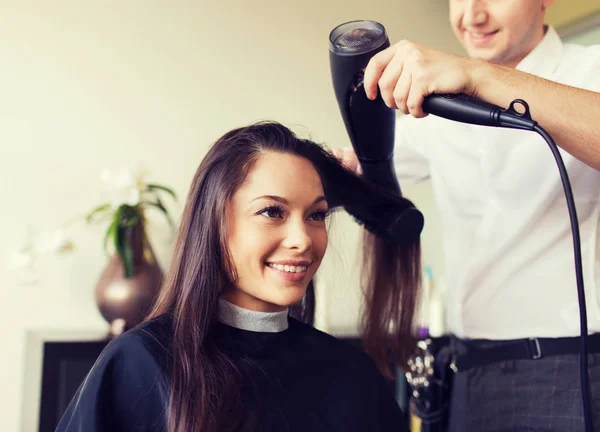 Mulher feliz com estilista fazendo penteado no salão — Fotografia de Stock