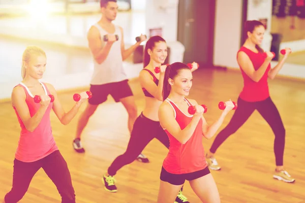 Group of smiling people working out with dumbbells — Stock Photo, Image