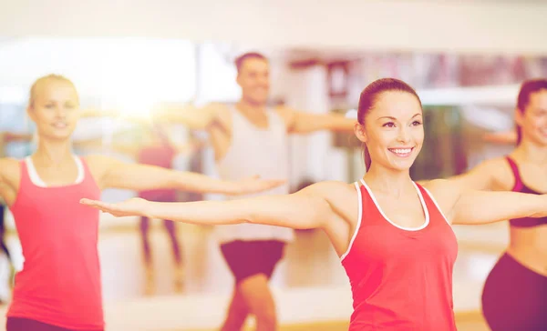 Groupe de personnes souriantes faisant de l'exercice dans la salle de gym — Photo